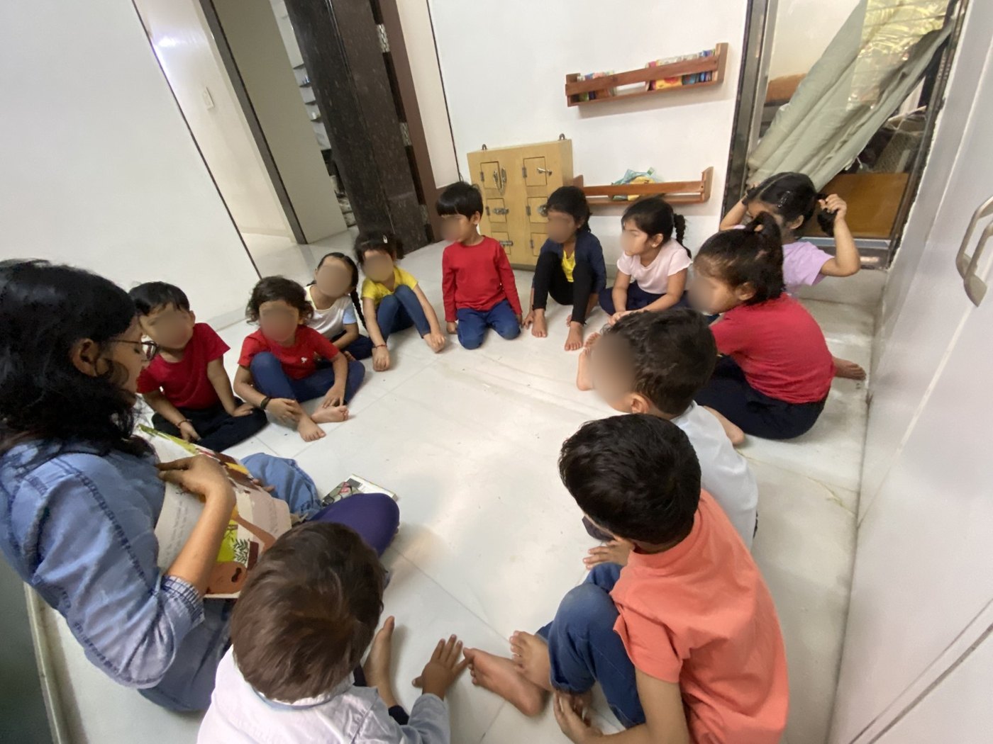 An educator reads to young children sitting in a circle