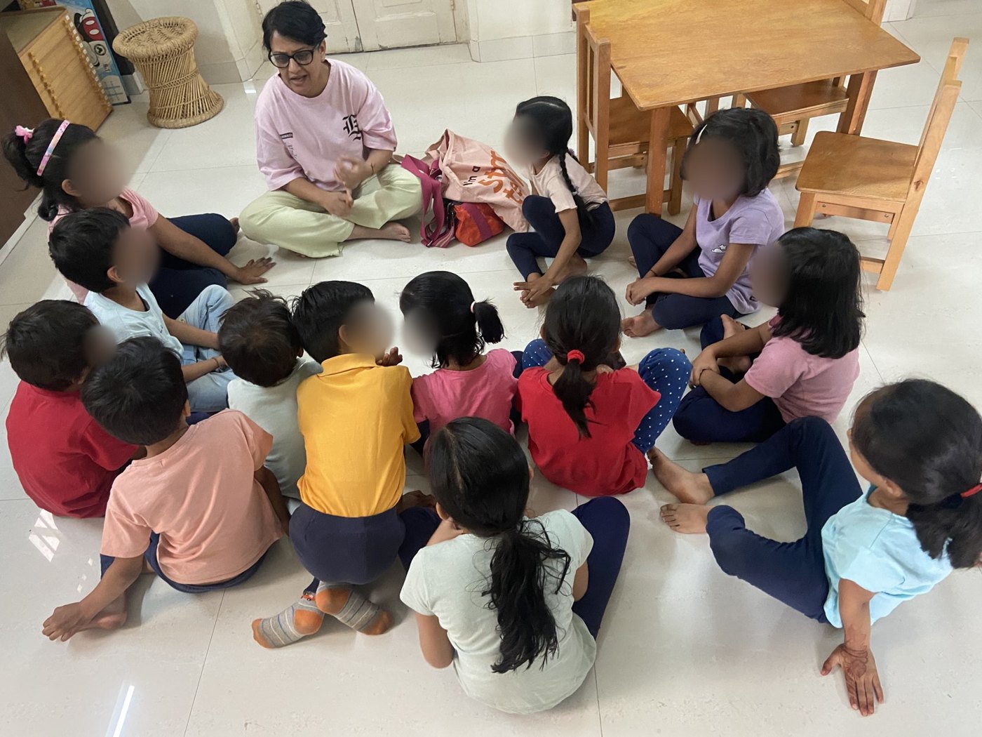 An educator talks with older children sitting in a circle