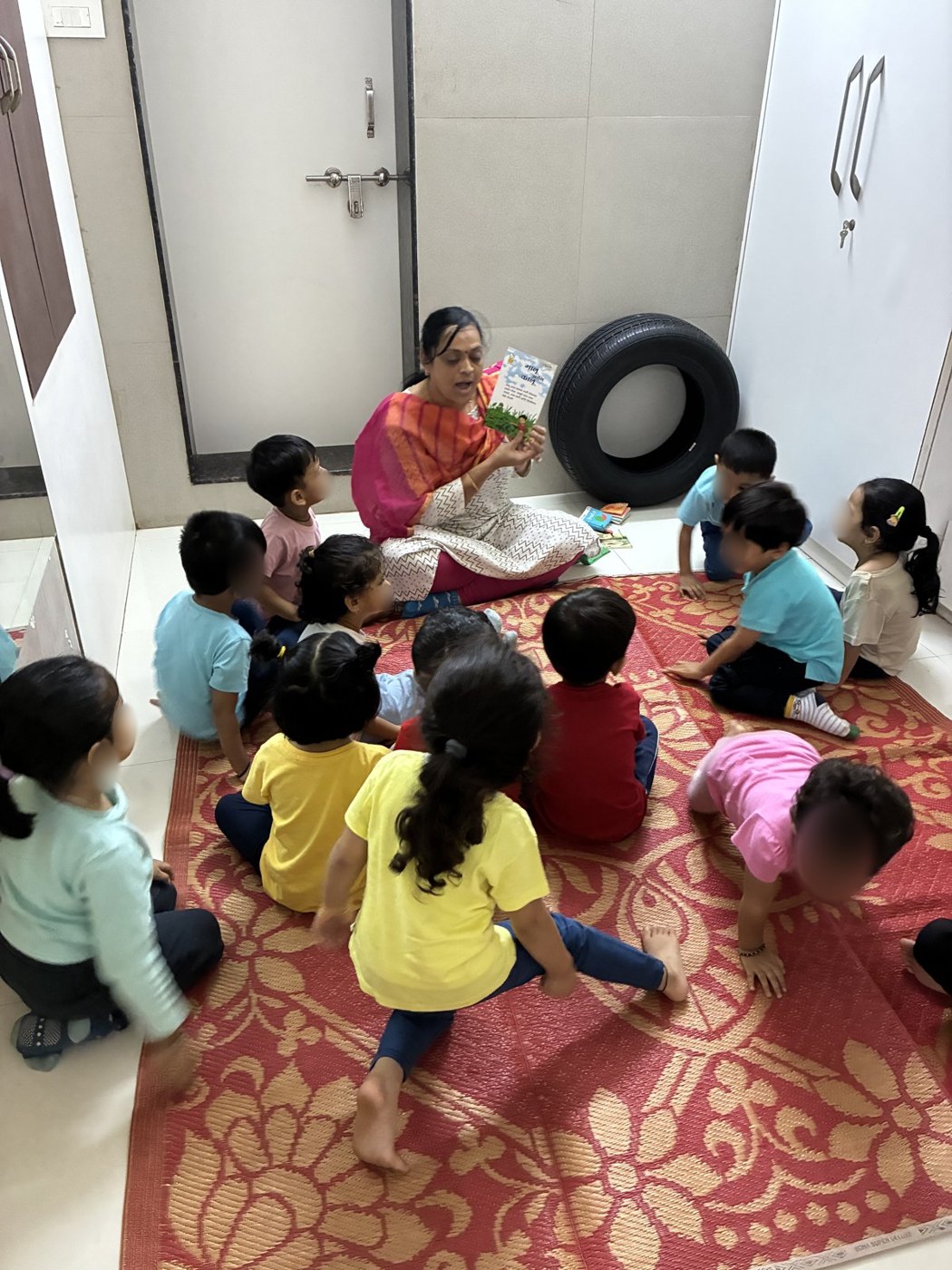 An educator reads a picture book to toddlers on a mat