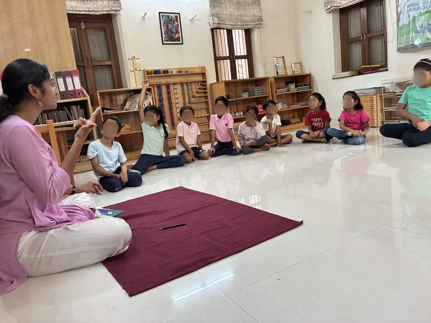 An educator talks with children sitting in a wide circle