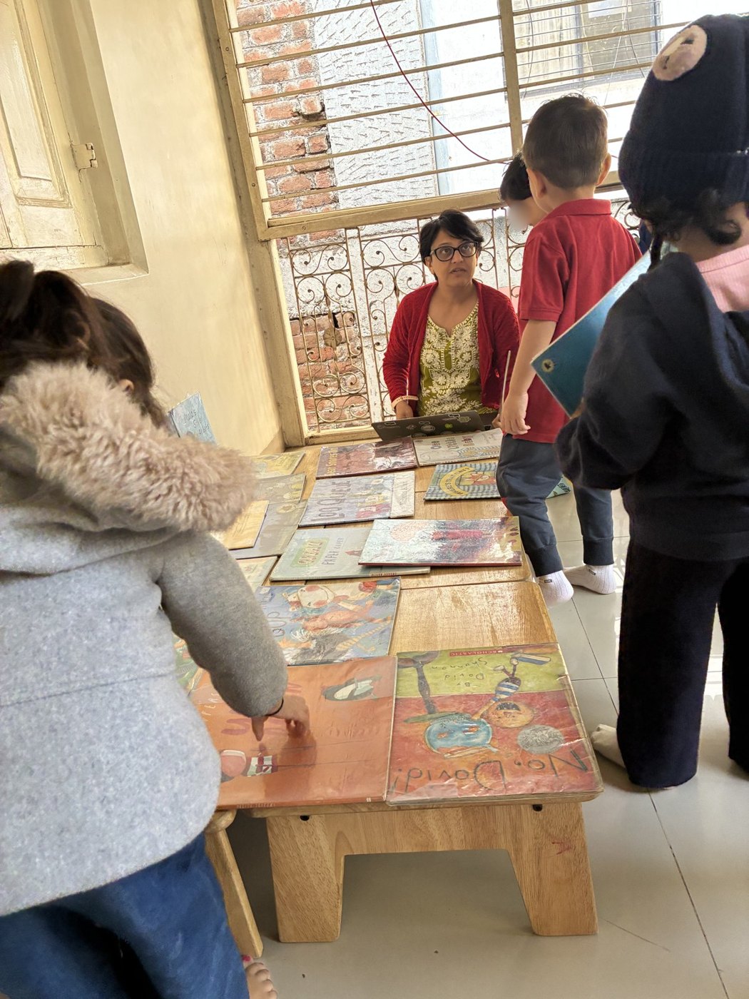 Children choose books from a low table