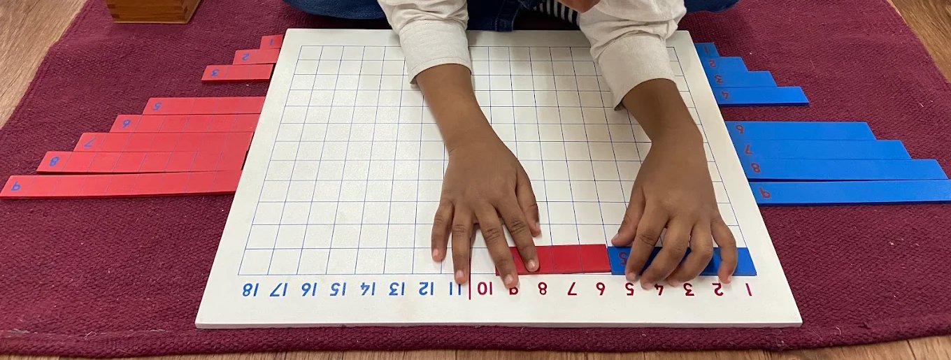 A child adds two number strips on an addition board